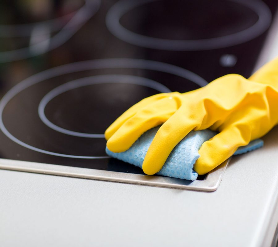 cleaning-stove-top-with-glove-and-cloth-2026-03-09-07-59-47-utc
